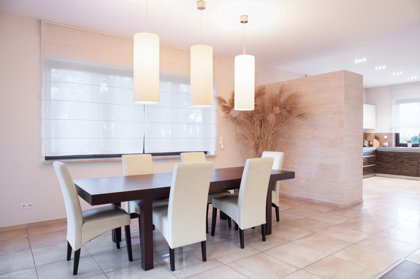 Dining room table with low lighting fixtures and upholstered chairs