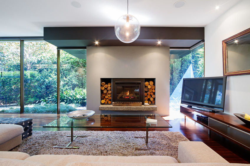 Contemporary living room with accent lighting over fireplace and task lighting over large coffee table.